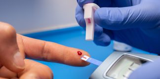 What Is Diabetes? Symptoms, Causes & Prevention Guide Person checking blood sugar using a glucometer at home to manage diabetes and prevent complications