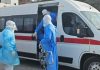 Medical team wearing PPE transferring a patient into an ambulance during emergency infectious disease response