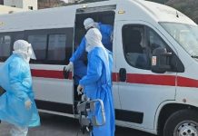 Medical team wearing PPE transferring a patient into an ambulance during emergency infectious disease response
